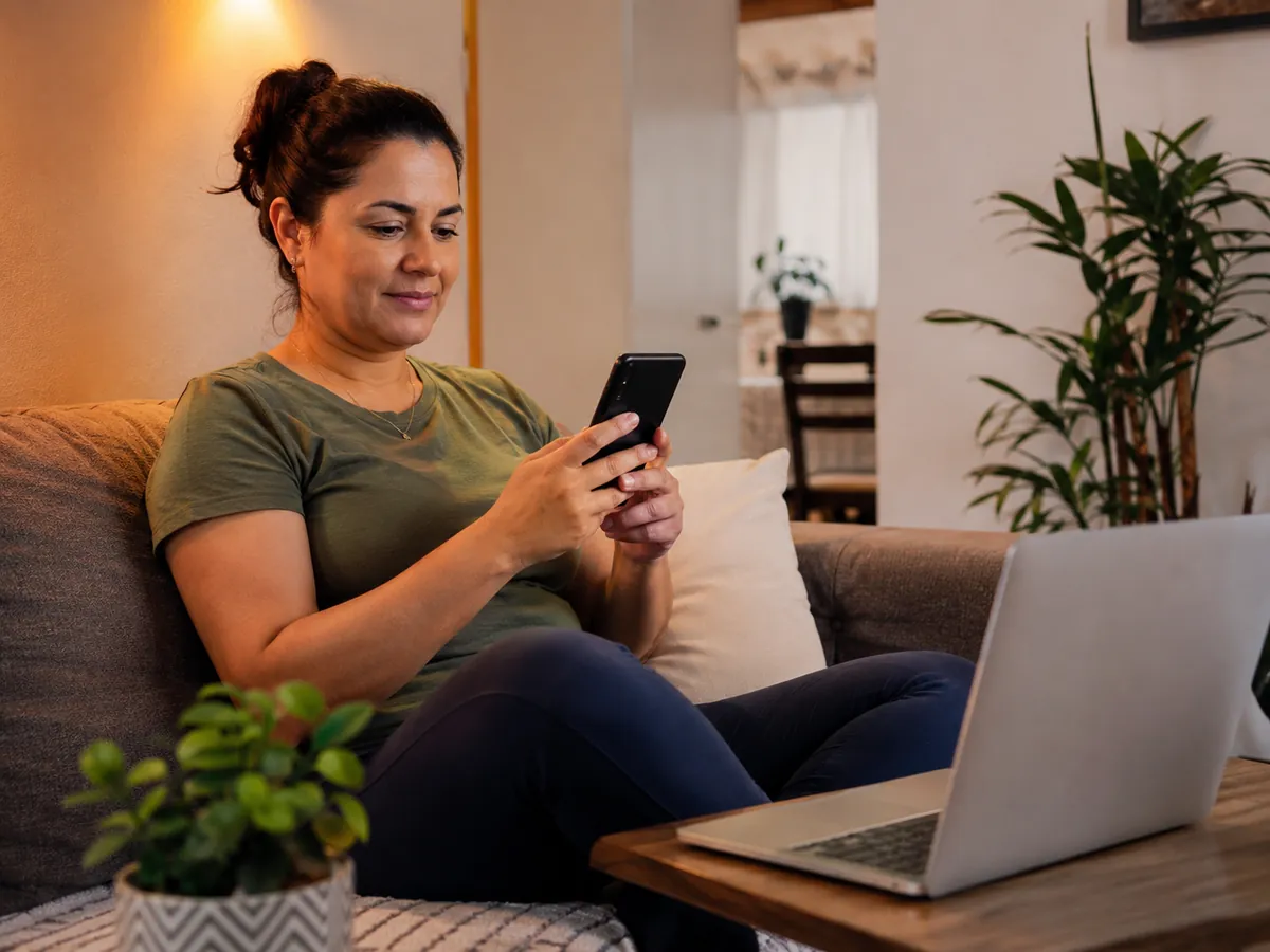 Woman using her phone on the sofa at home